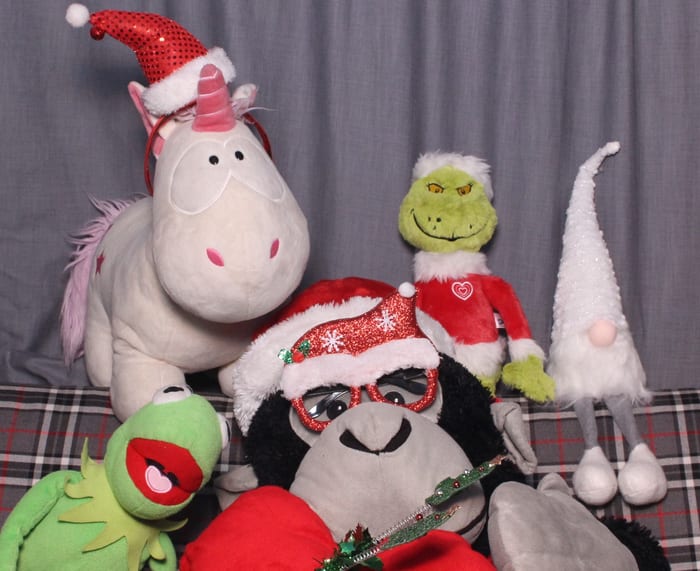 Weihnachtliche Plüsch-Requisiten mit Nikolausmützen vor dem Fotohintergrund im Bulli, darunter Einhorn und Kermit.